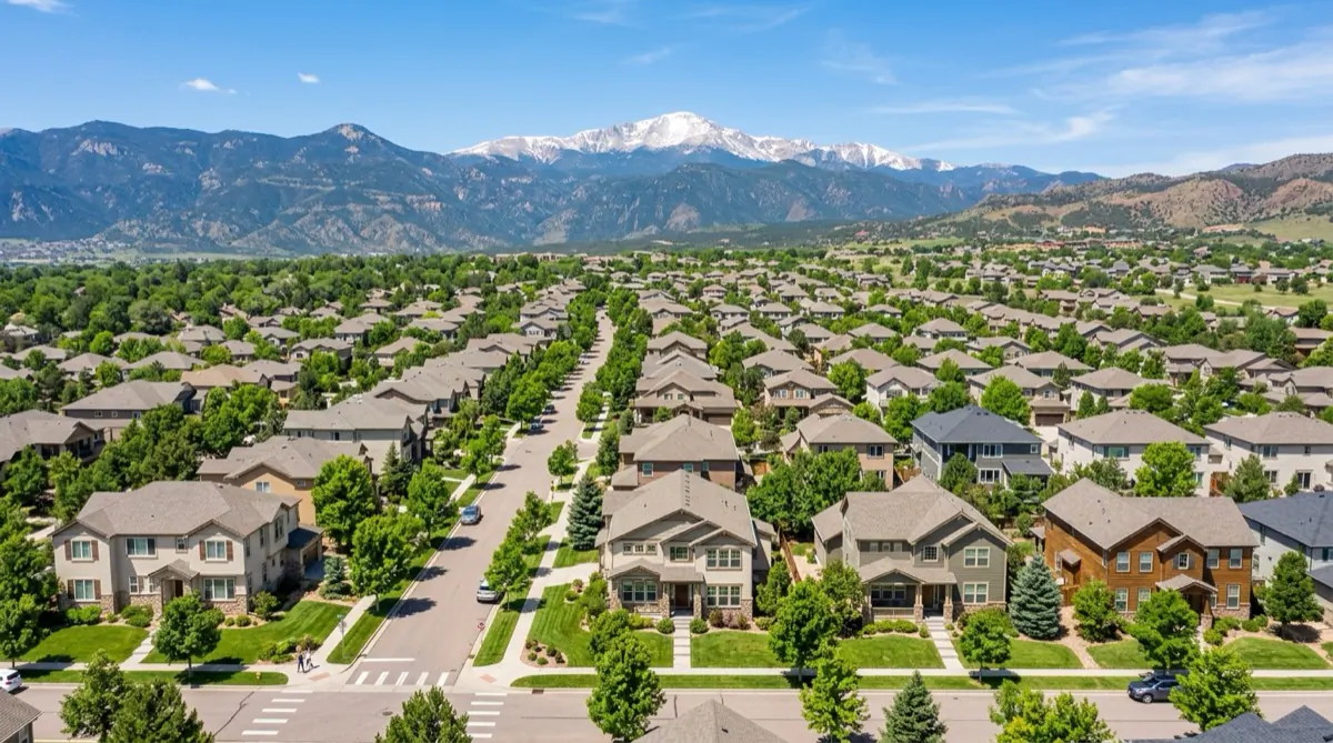 Aerial view of a well-maintained Colorado Springs neighborhood with mountain backdrop